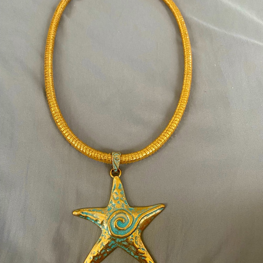 Blue tone stat fish pendant on 20in gold leather  cord. Magnetic closur